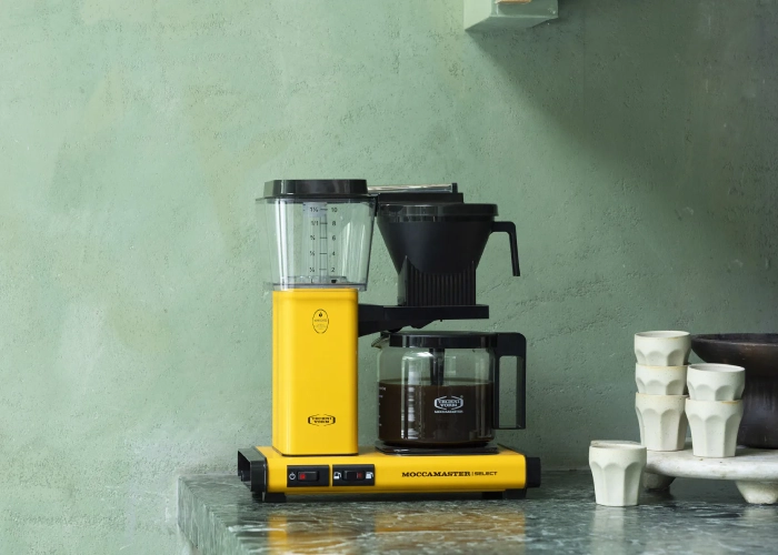 Moccamaster KBG Select Yellow Pepper na zielonym kamiennym tle
